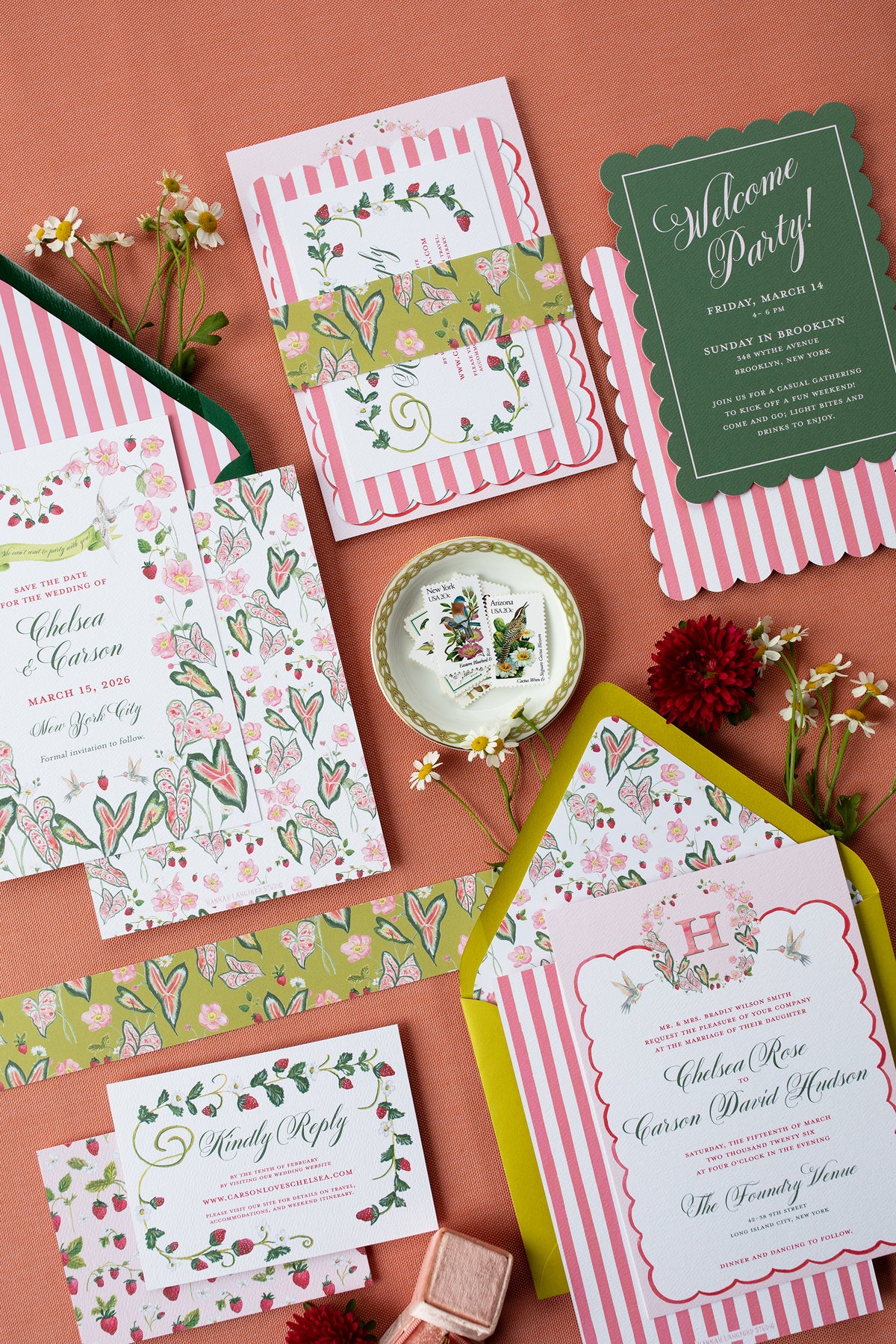 Collection of wedding invitations and stationery items on a red background