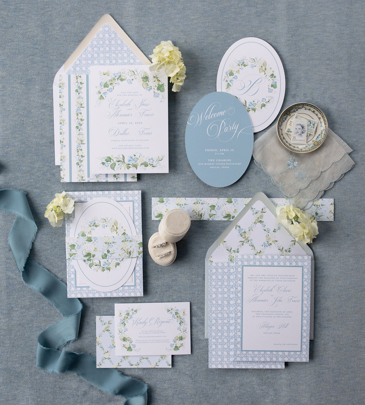 Blue floral wedding invitation on a fabric background.