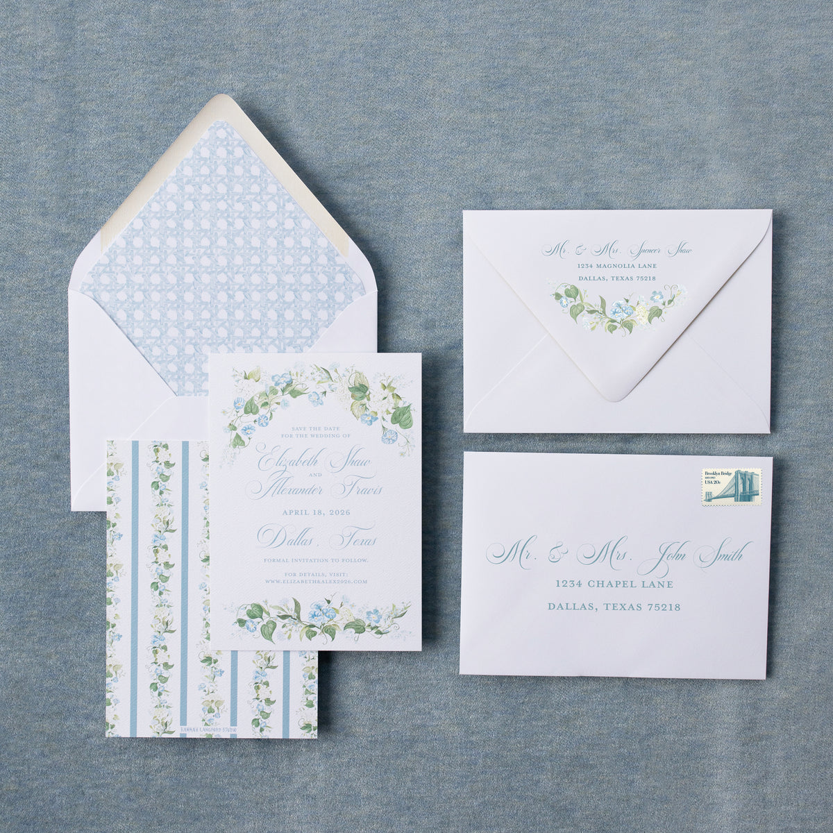 Set of wedding invitations with floral designs on a textured gray surface