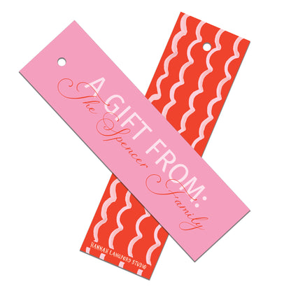 Two gift tags, one pink with text and the other red with wavy pattern, on a white background.