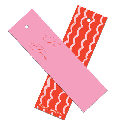 Two colorful gift tags, one pink with cursive text and one red with wavy patterns, on a white background.