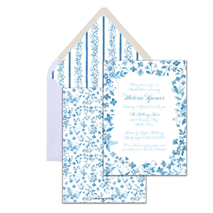 A blue watercolor floral invitation card with text space and a white envelope with a blue striped liner.