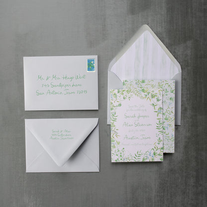 Set of wedding invitations with envelopes on a gray background
