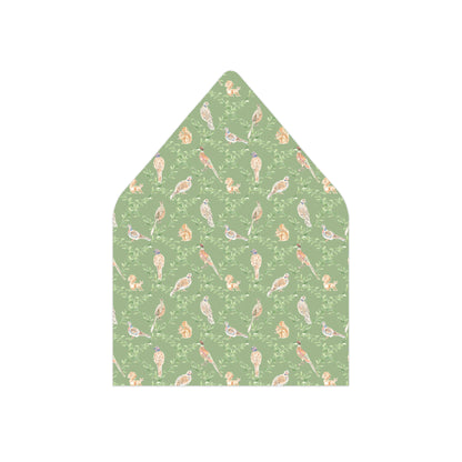 A pointed envelope liner featuring a repeating pattern of small birds, squirrels, and acorns in muted orange, beige, and purple tones on a sage green background, shown on a plain white background.