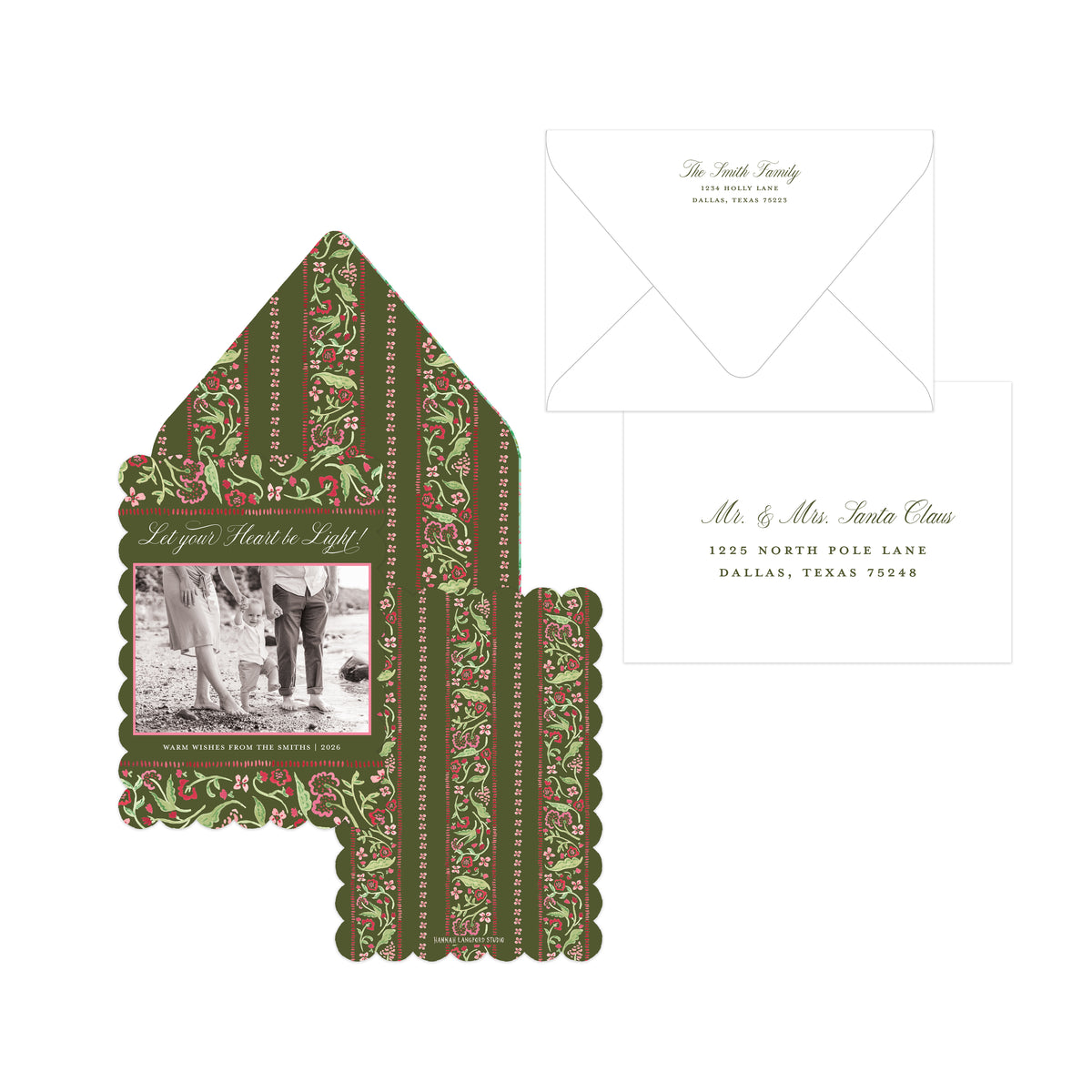 A holiday-themed stationery set featuring a house-shaped envelope with a green and red patterned border and a photo insert, alongside a white address insert card and a white envelope on a plain white background.
