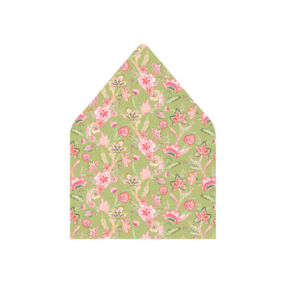 A pointed envelope flap or paper envelope with a light green background and an all-over floral print in pink, coral, and cream, shown on a plain white background.