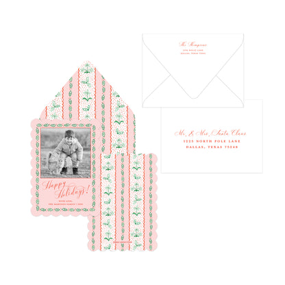 A holiday-themed stationery set featuring a scalloped 'Happy Holidays!' card with a photo placeholder, matching patterned envelope liner, and white envelopes with coral script text, all arranged on a plain white background.