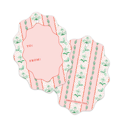 Two scalloped gift tags with a pink and white striped pattern, decorated with green botanical motifs. 
