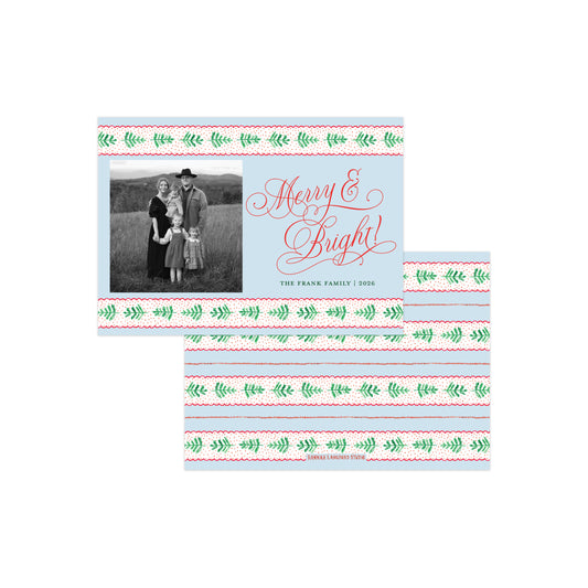 A holiday photo card set displayed on a white background, featuring a larger front card and two matching folded cards behind it. The card design has a pale blue center, a black-and-white family photo on the left, red cursive 'Merry & Bright!' text, and green and red decorative border stripes.