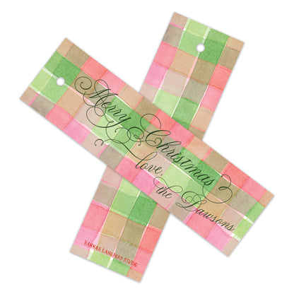 Two personalized Christmas gift tags with a pink, green, and beige plaid pattern, featuring the text 'Merry Christmas love the Dawson's' in black cursive script.