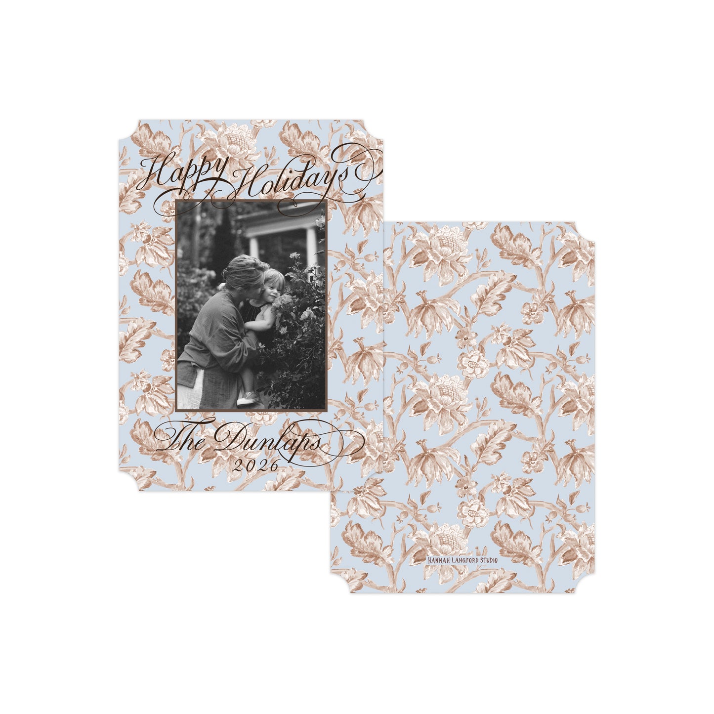 Two personalized holiday photo cards with a light blue background and a rose gold floral pattern, displayed on a clean white background.