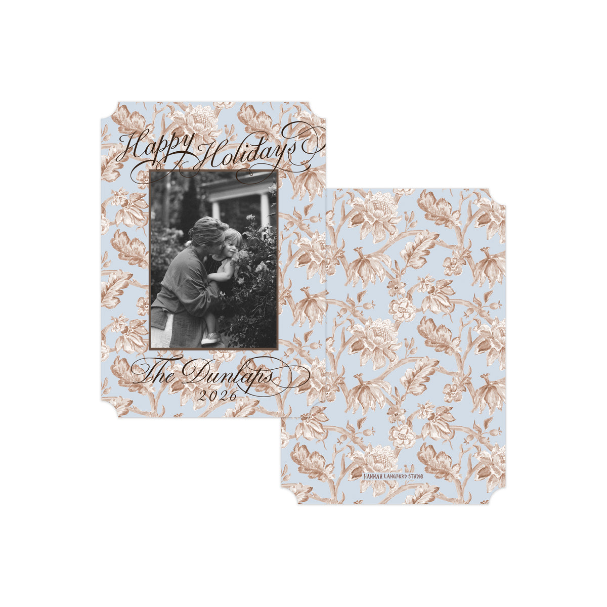 Two personalized holiday photo cards with a light blue background and a rose gold floral pattern, displayed on a clean white background.