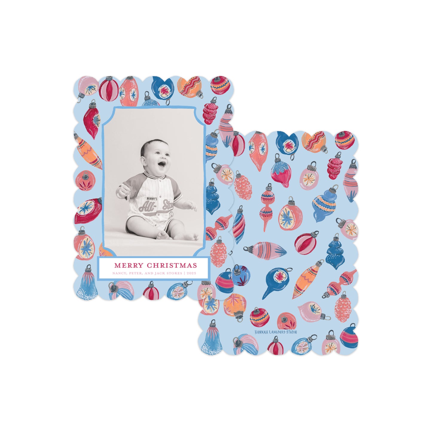 Two scalloped Christmas photo cards with a light blue background and colorful ornament illustrations, shown overlapping on a white background. 