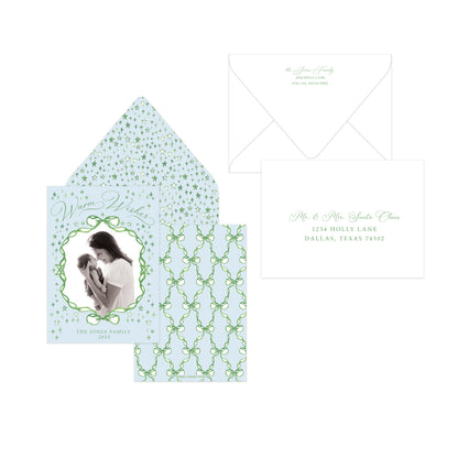 A personalized family invitation suite featuring a light blue envelope with green trellis patterns, a matching patterned insert card with a photo frame, and a white address card with green script text, all arranged on a white background.
