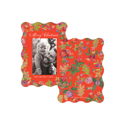 Two scalloped holiday photo frames with a vibrant red background and an all-over botanical print of pomegranates, leaves, and flowers. 