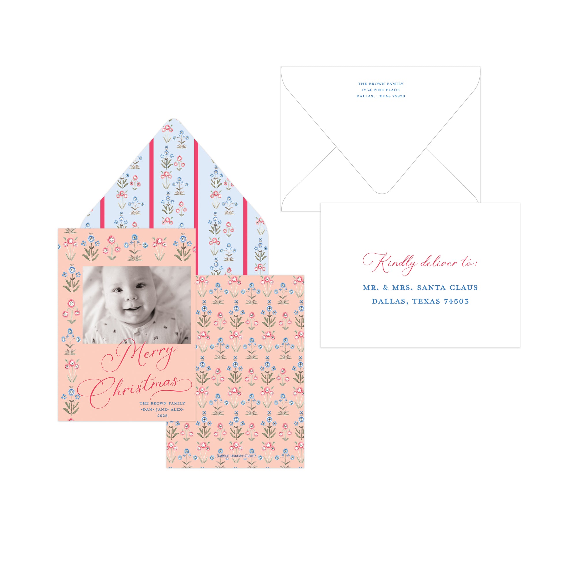 A Christmas personalized card set featuring a peach and blue floral patterned card with a baby photo, matching patterned envelope liner, a white envelope, and a white reply card with pink and blue text.