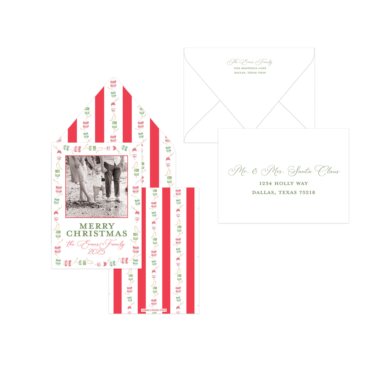 A holiday-themed stationery set featuring a personalized Christmas card with a photo placeholder, a matching striped envelope, and a white envelope with elegant script text, all arranged on a clean white background.