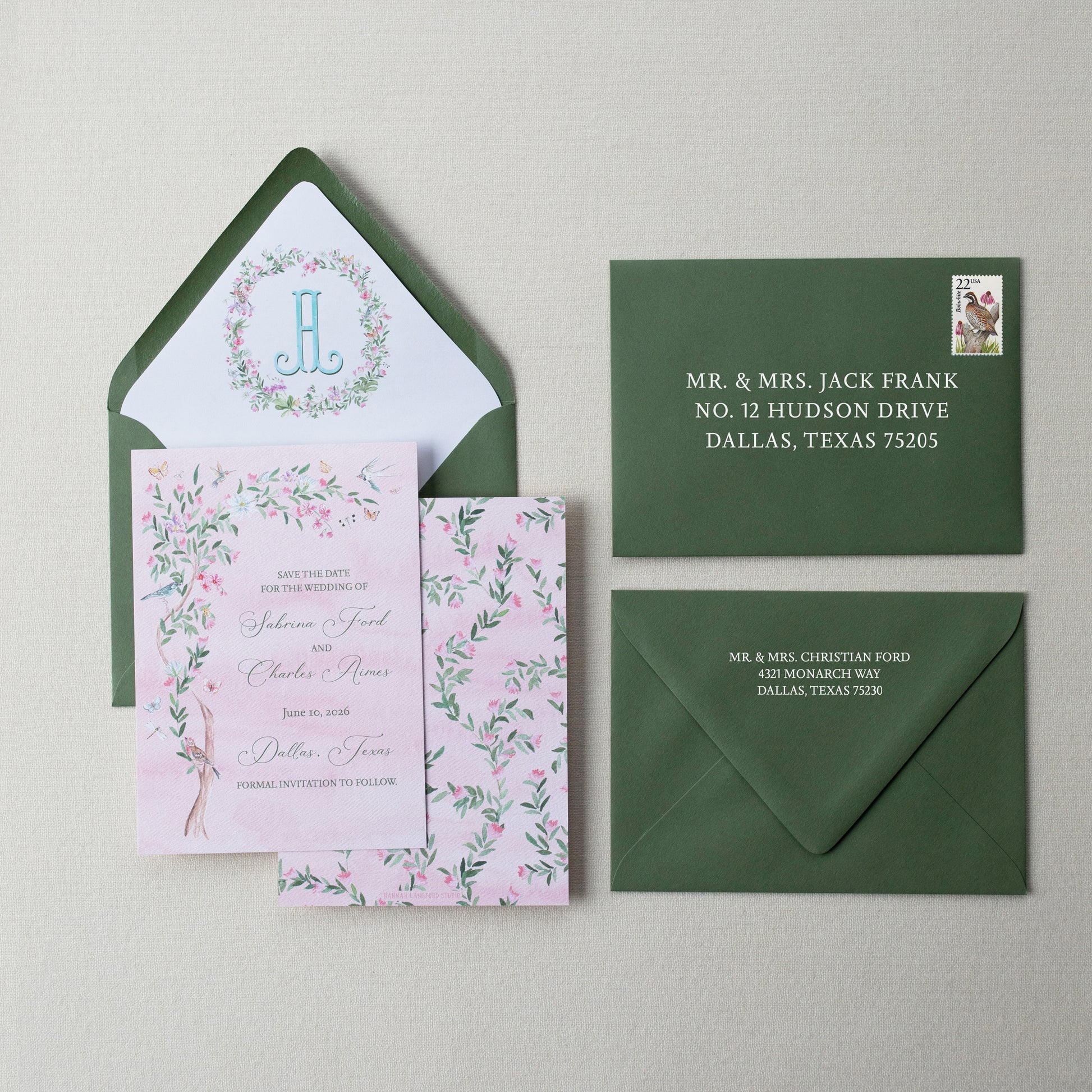 Wedding invitation set with pink card, green envelopes, and floral design on a beige background