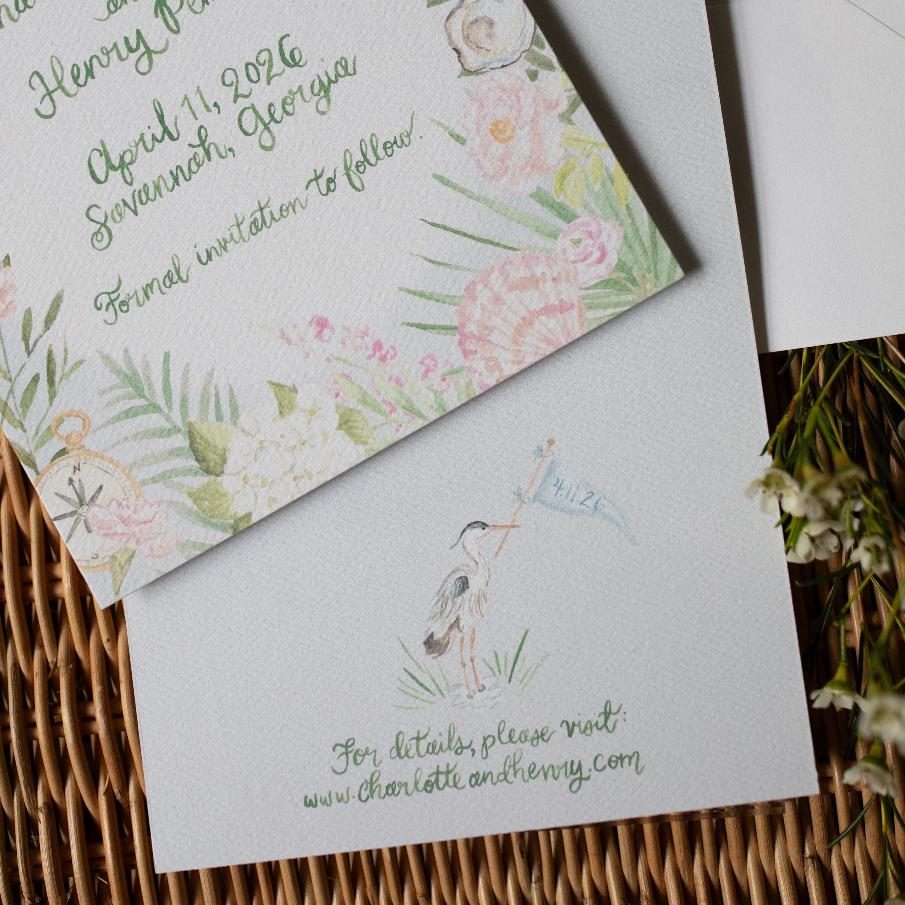 Floral invitation card with envelope on a woven surface