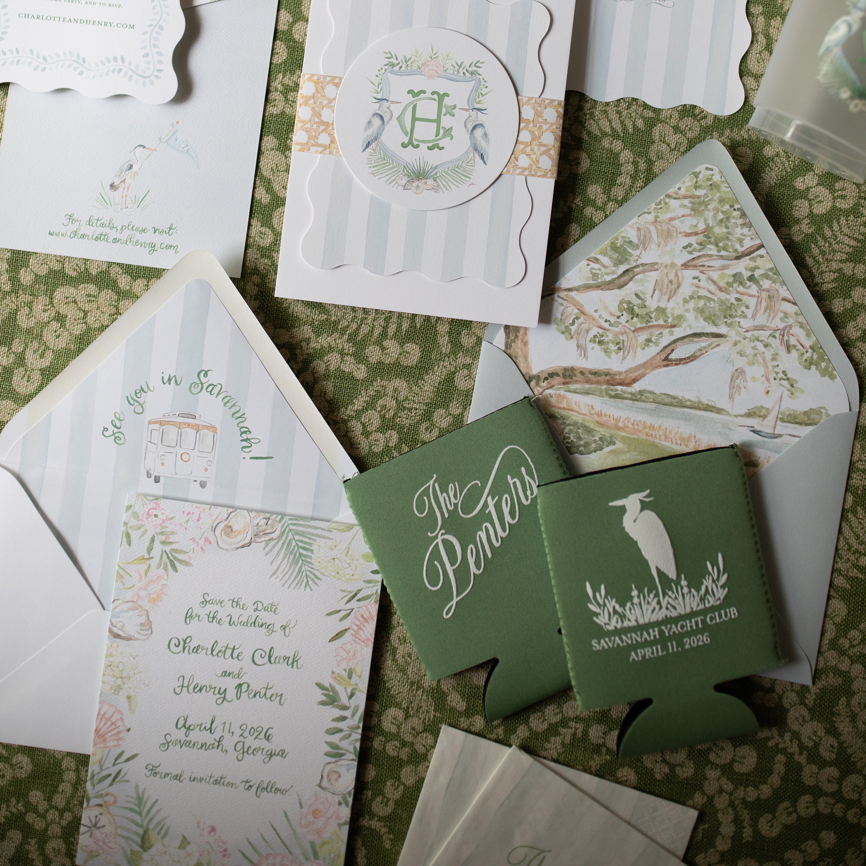Collection of wedding invitations and can coolers on a patterned surface
