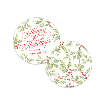 Two personalized round holiday gift tags with a white background, green holly leaf pattern, and red berries. One tag displays 'Happy Holidays! LOVE, THE SMITHS' in red script.