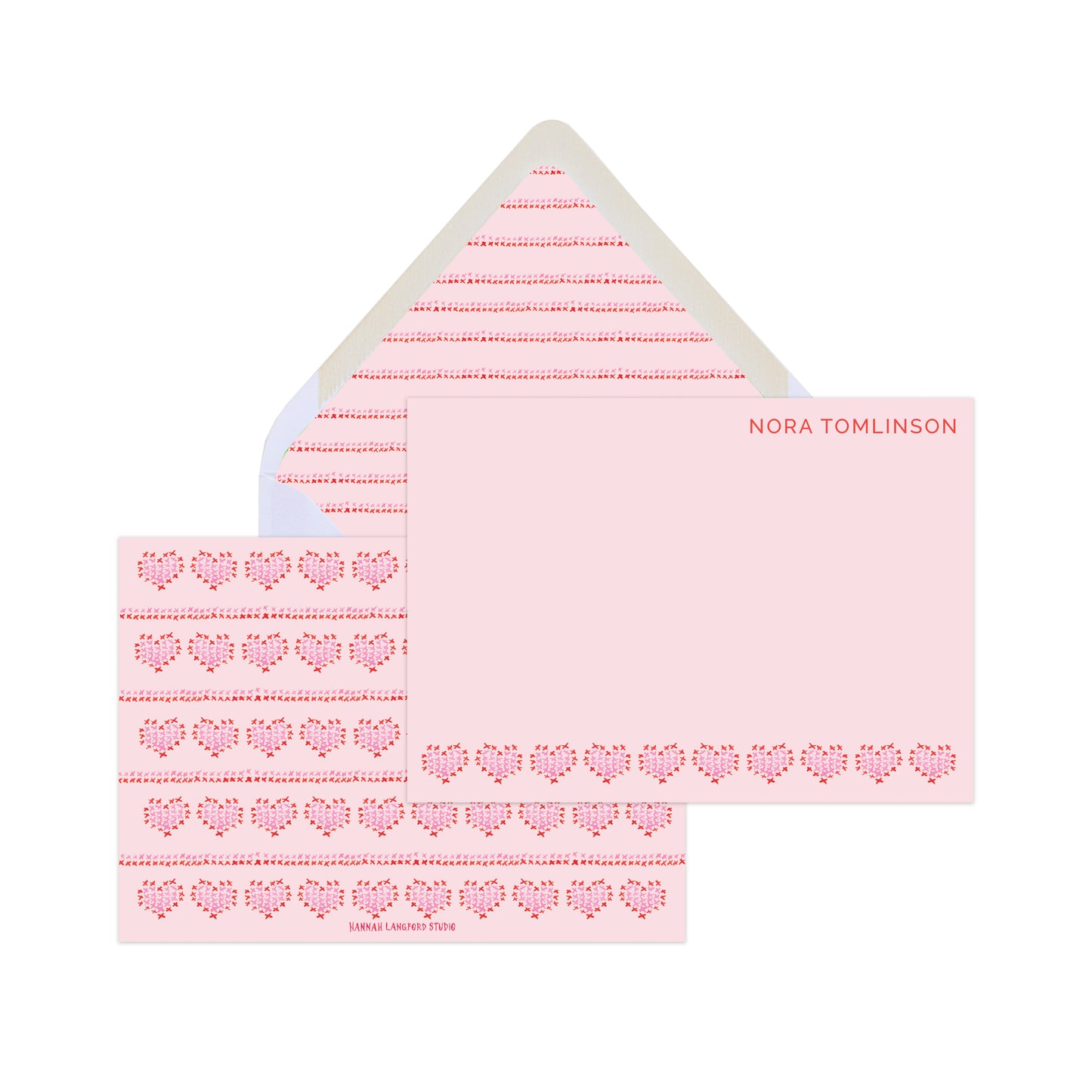 Pink and red cards with illustrations of heart-shaped embroidery and text that reads "Nora Tomlinson" with a patterned envelope. 