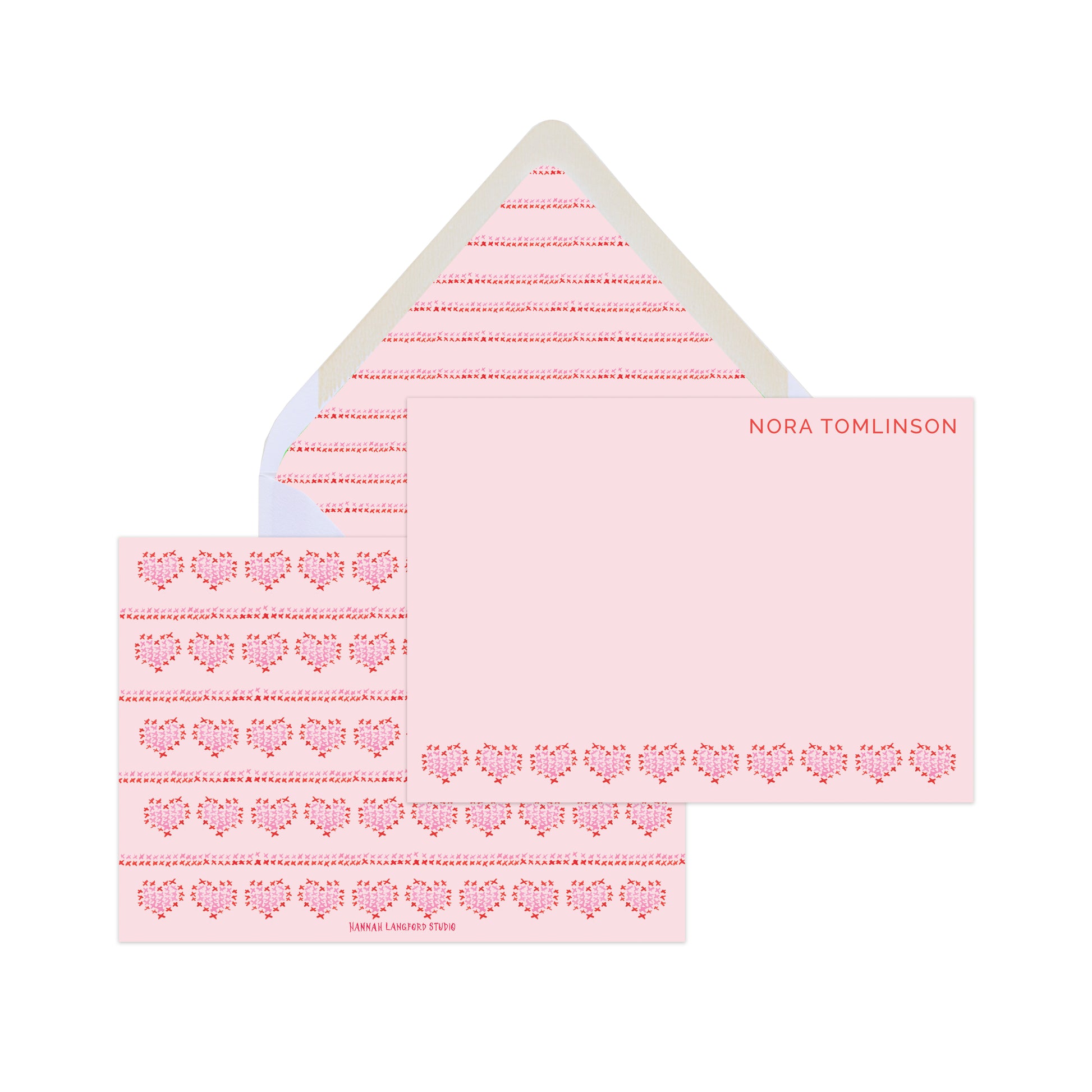 Pink and red cards with illustrations of heart-shaped embroidery and text that reads "Nora Tomlinson" with a patterned envelope. 