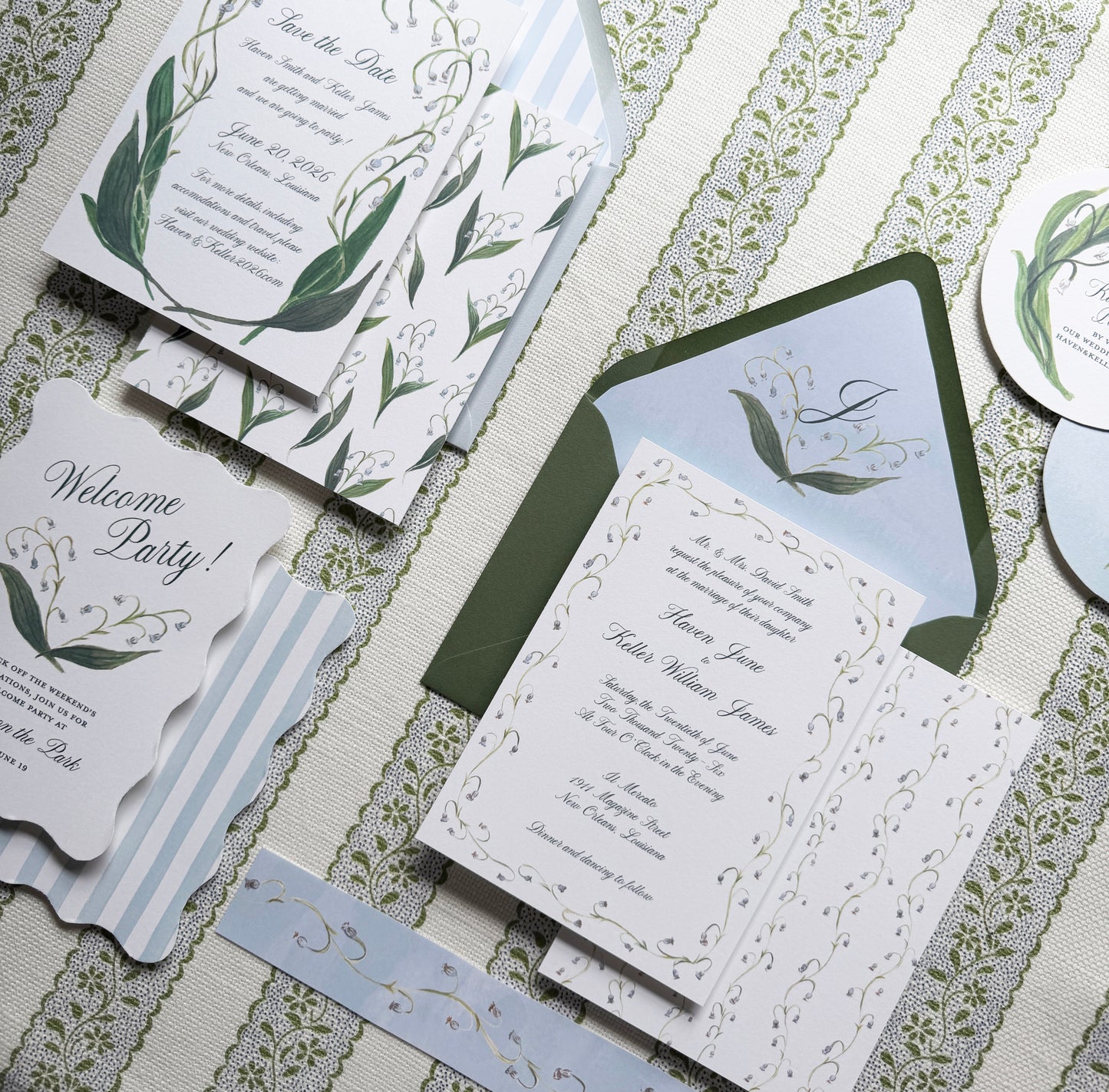 Set of wedding invitations with greenery design on a textured surface