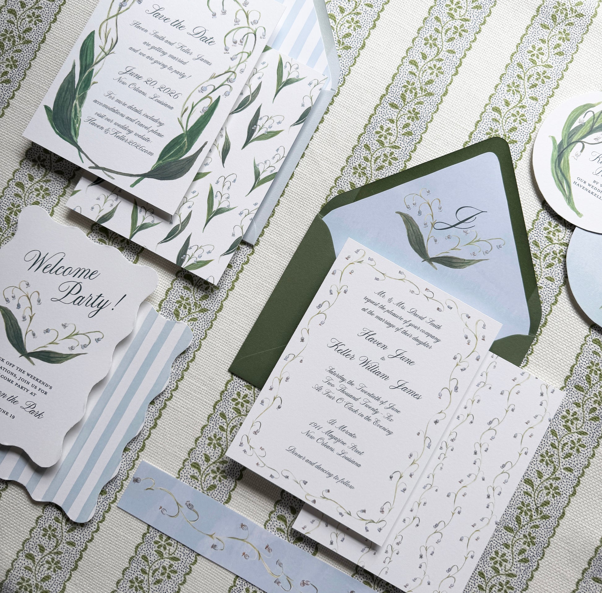 Set of wedding invitations with greenery design on a textured surface