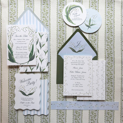 Wedding invitation set with greenery design on a textured background