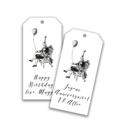 Two customizable gift tags with black and white illustrations of people and text reading 'Happy Birthday' and 'Joyeux Anniversaire'.