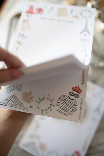 Hand holding a small book or notebook with decorative elements on the cover.