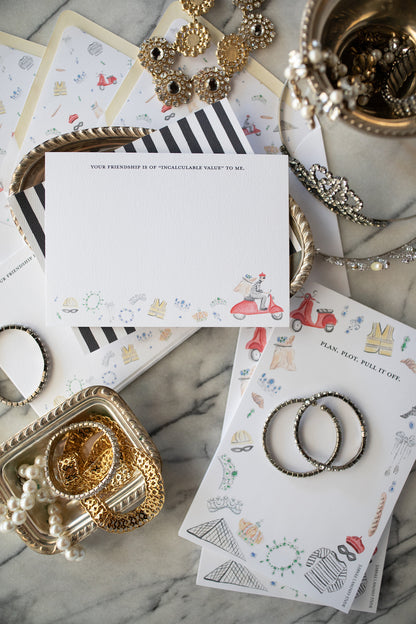 Jewelry and stationery items on a marble surface