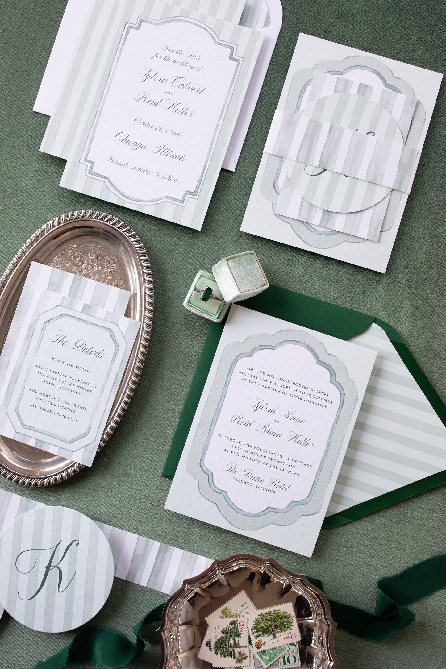 Wedding invitation cards with green and white design on a textured surface