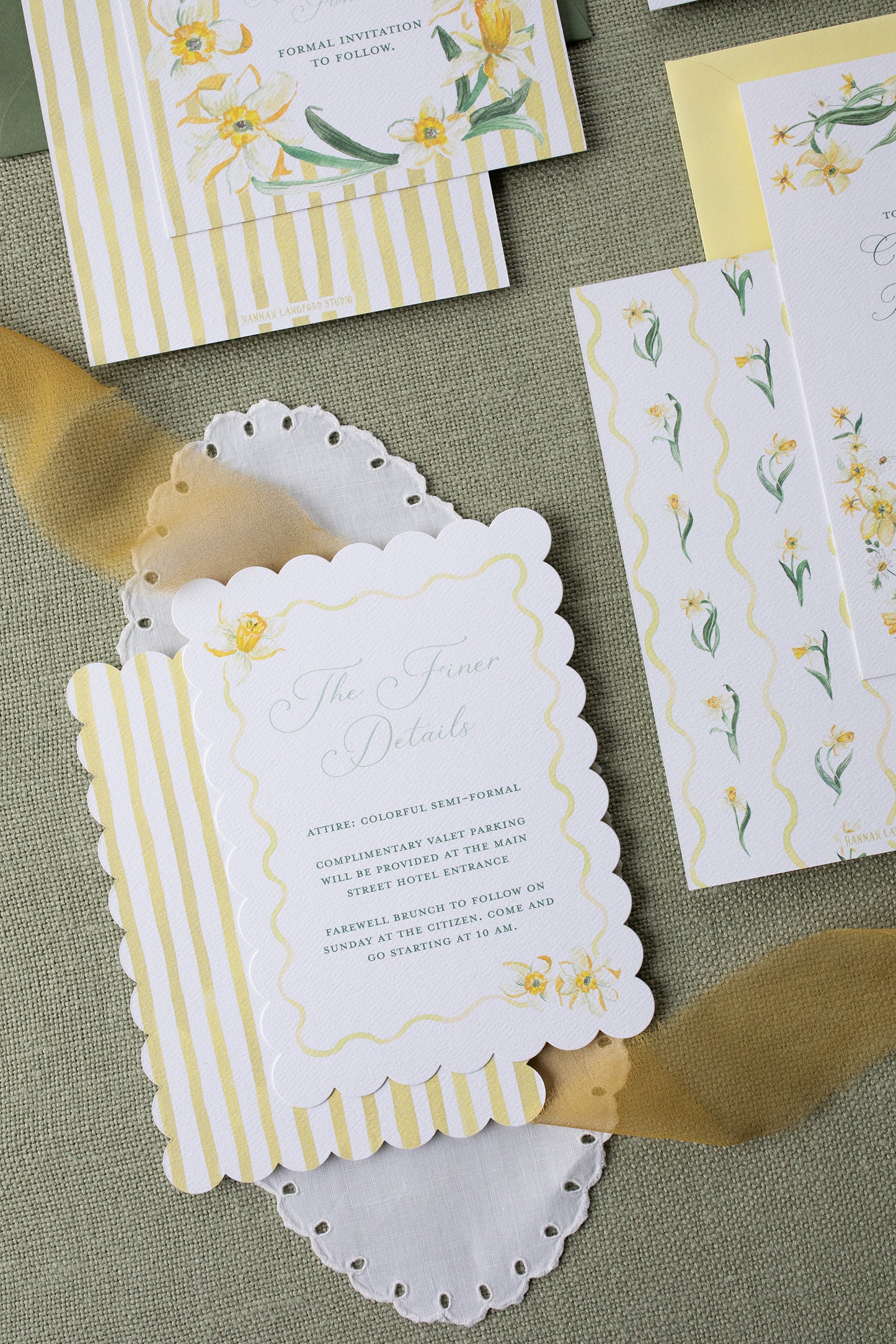 Invitation card with floral design and gold accents on a textured surface