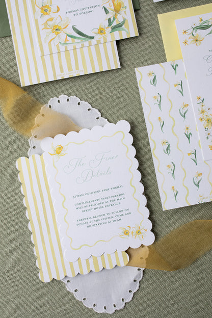 Invitation card with floral design and gold accents on a textured surface