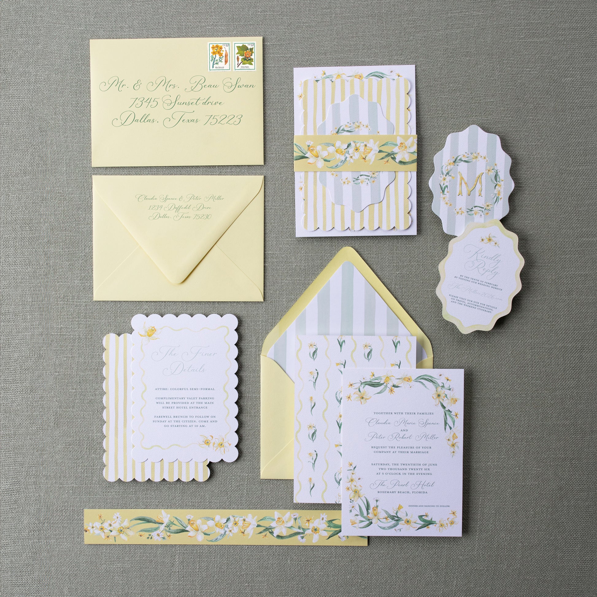 Collection of yellow and white wedding invitations on a gray surface