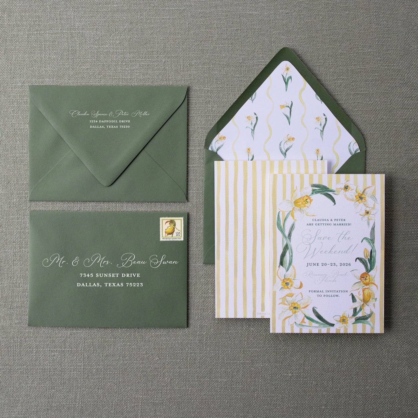 Wedding invitation set with green envelope and floral design on a gray background