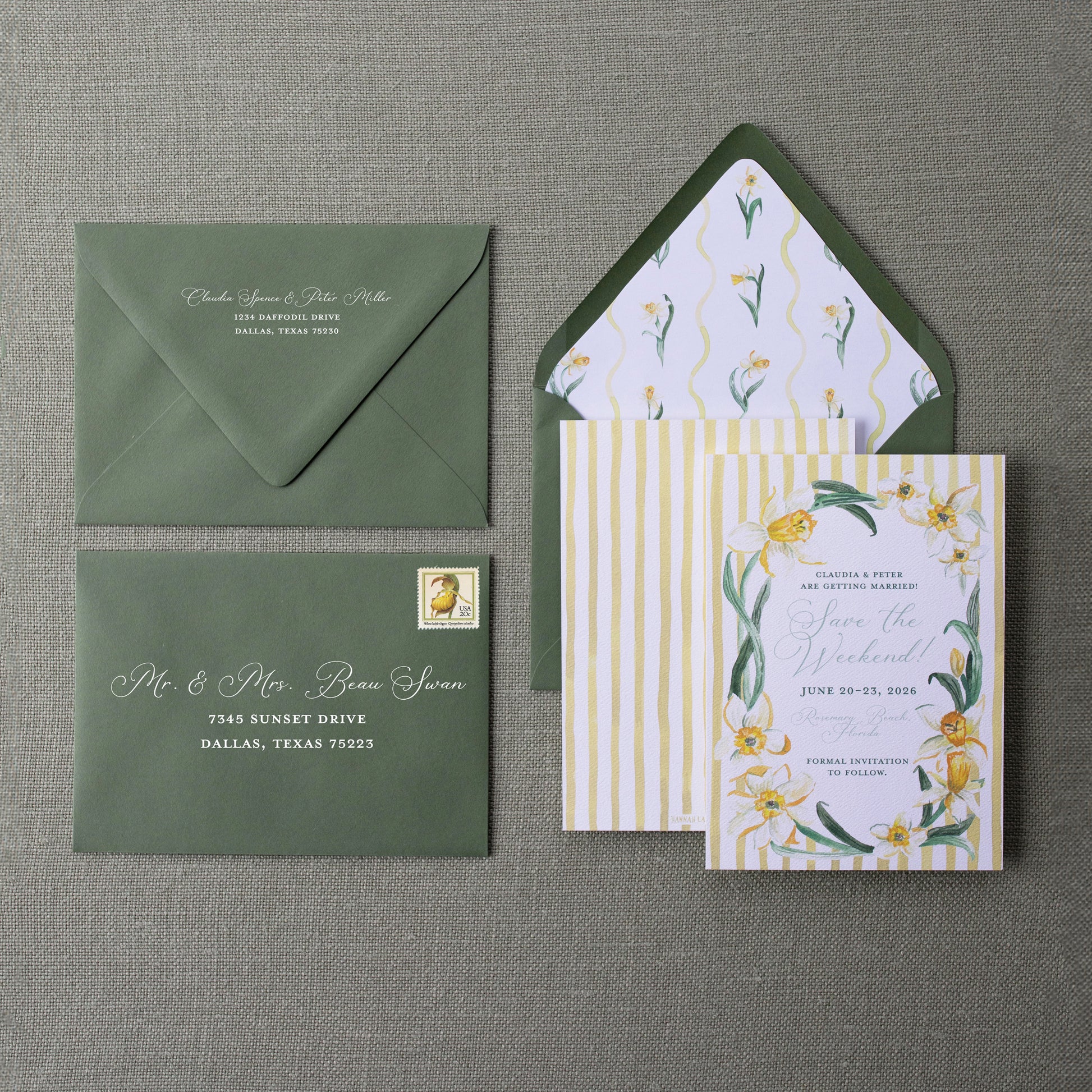 Wedding invitation set with green envelope and floral design on a gray background
