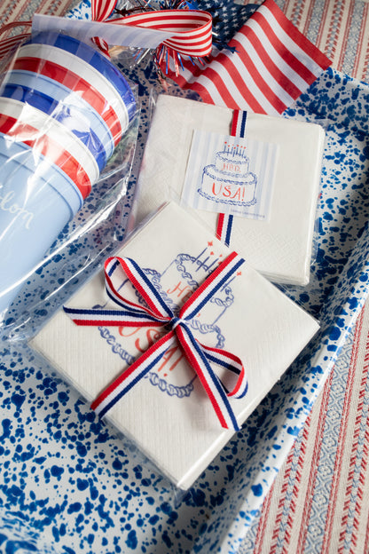 Gift boxes with red, white, and blue ribbons on a patterned surface