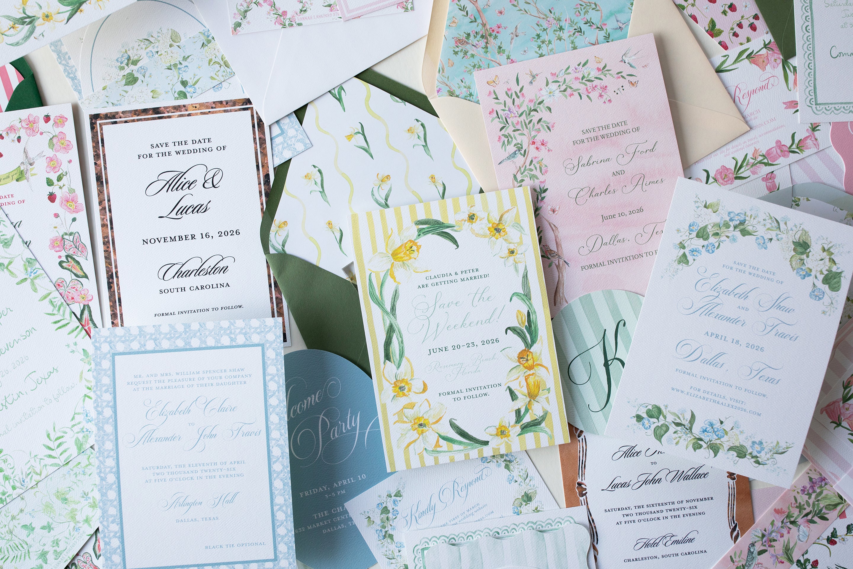Collection of wedding invitations with floral and stationery designs on a white surface.