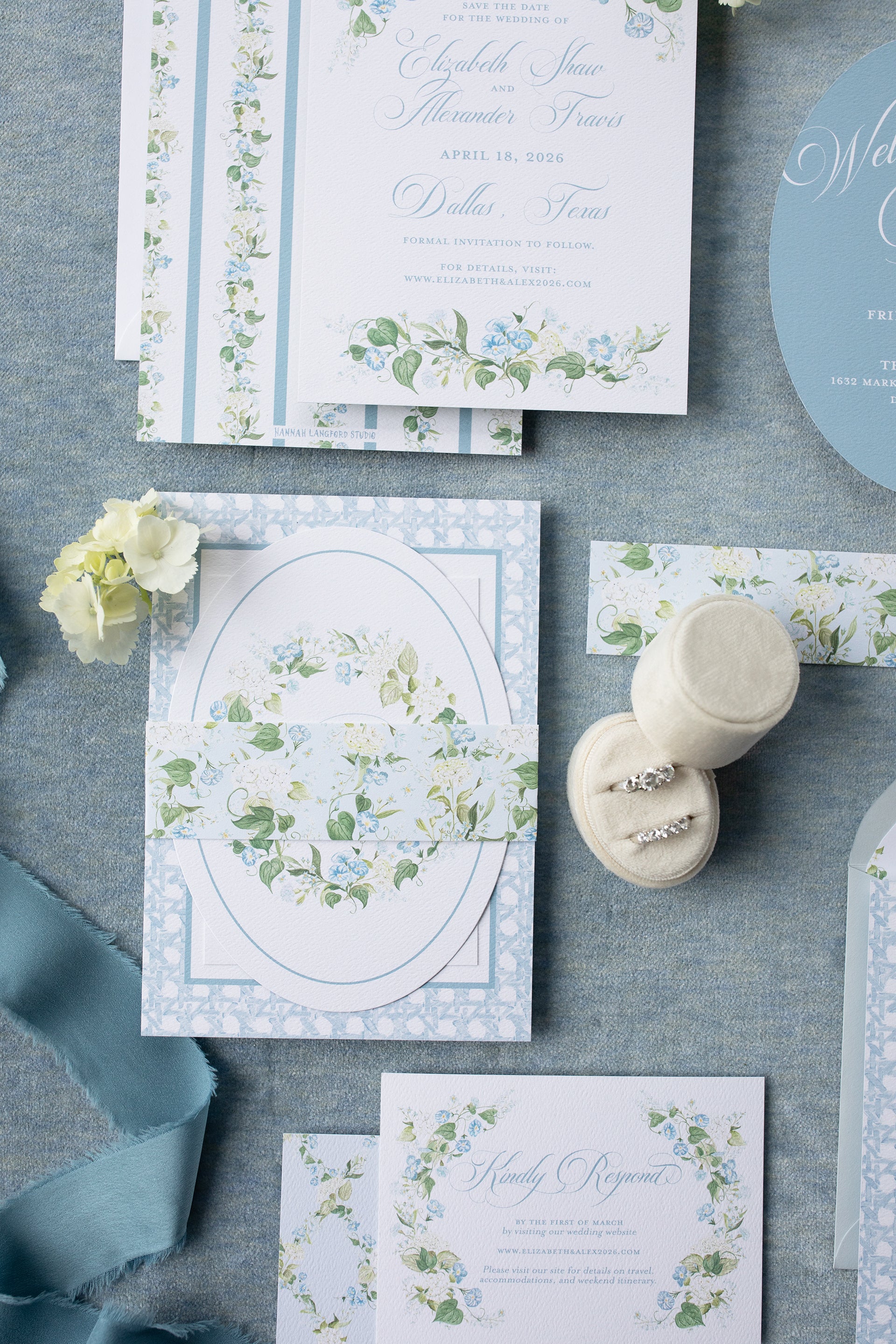 Wedding invitation set with floral designs on a gray surface