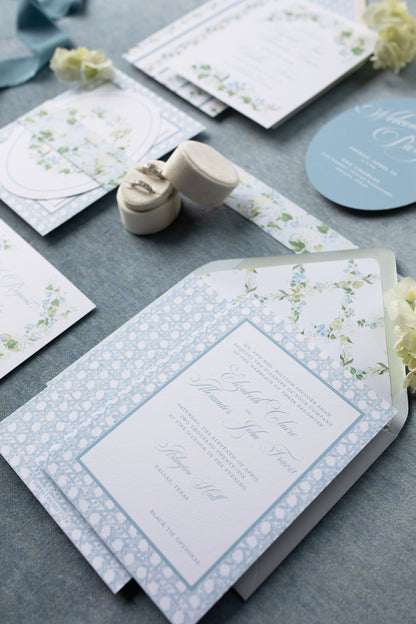 Wedding invitation set with floral designs on a gray surface