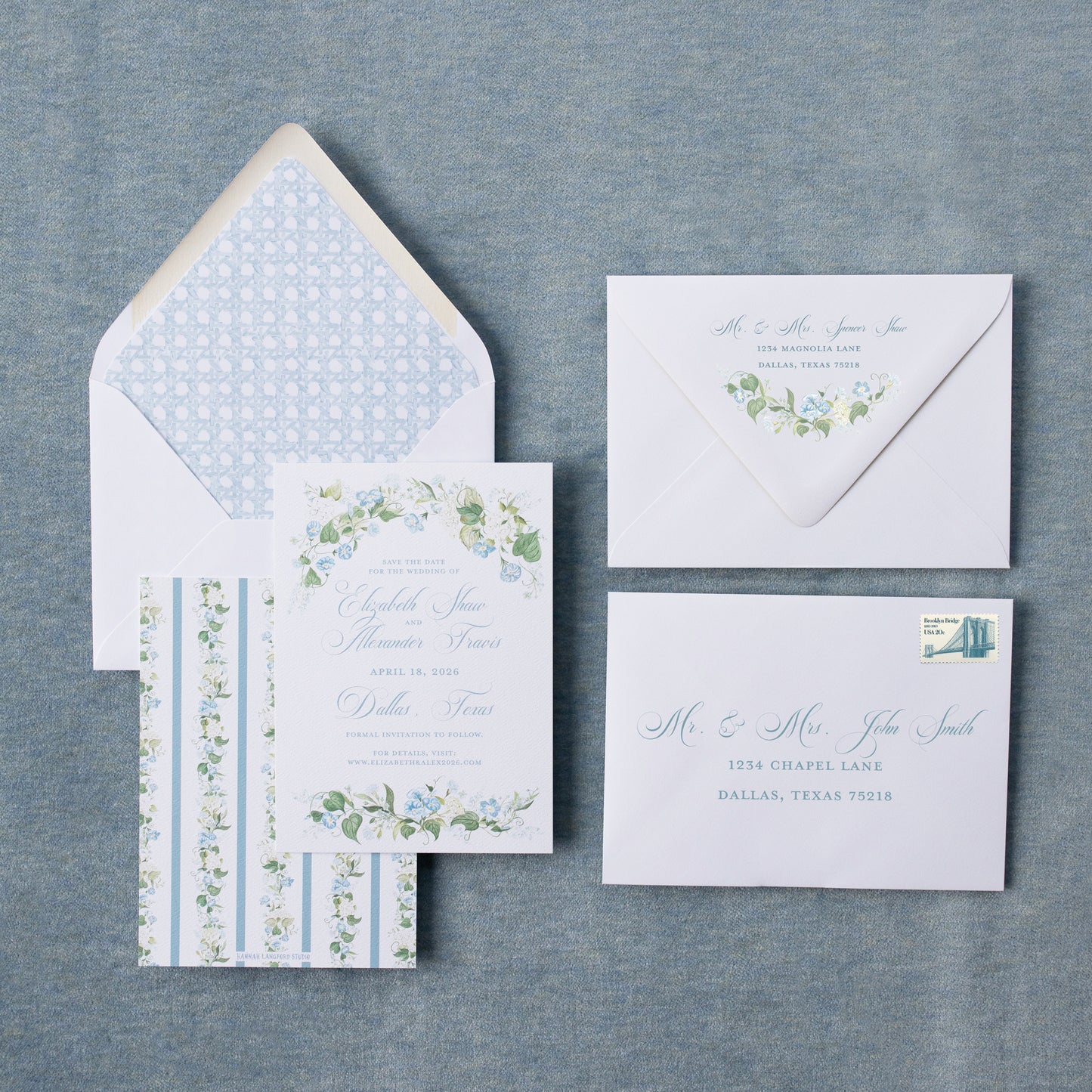 Set of wedding invitations with floral designs on a textured gray surface
