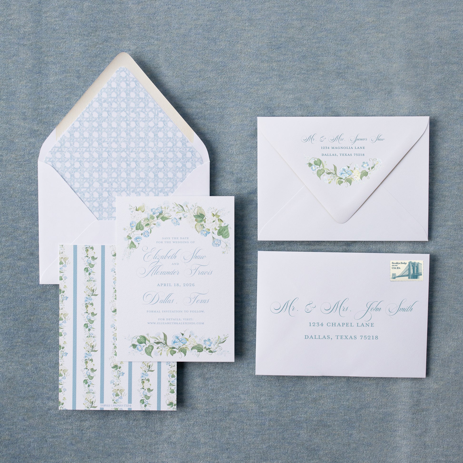 Set of wedding invitations with floral designs on a textured gray surface