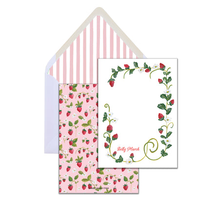 A set of stationery with a strawberry and floral pattern, including a card and an envelope with a striped design.