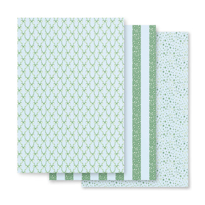 wrapping paper with green and blue illustrations of stars and bows.
